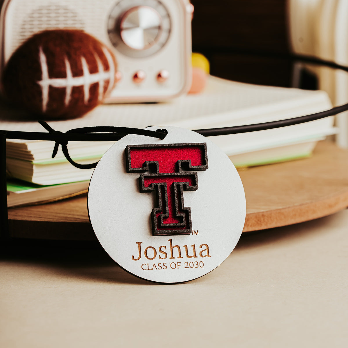 White Texas Tech ornament with a black cord, personalized with the name Joshua and Class of 2030. 