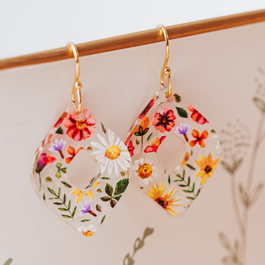 Clear acrylic floral dangle earrings with stainless steel gold-tone earring hooks